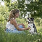 Foto von einer jungen Frau mit ihrem Hund in schöner grüner Natur